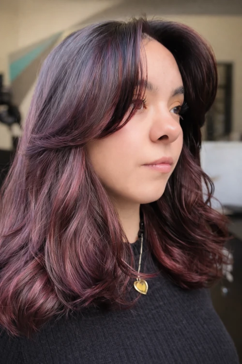 Estilista mostrando resultado de corte de cabello en clienta satisfecha